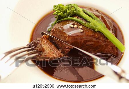 Stock Photograph - Plate of braised beef, close up, white background. Fotosearch