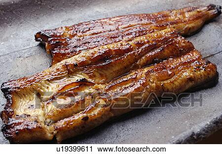 Stock Image - Plate of grilled eel, close up. Fotosearch
