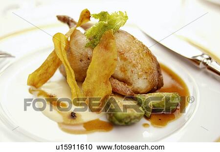 Stock Image - Plate of roasted quail, close up. Fotosearch