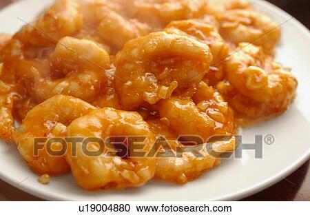 Stock Image - Plate of shrimps with chili sauce, close up. Fotosearch