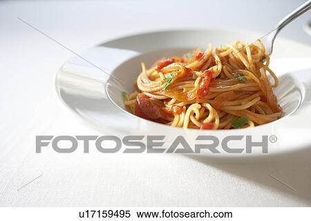 Stock Photography - Plate of tomato spaghetti, white background. Fotosearch