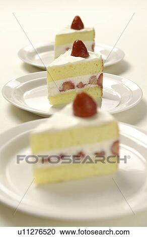 Stock Image - Plates of sliced strawberry cakes, white background. Fotosearch
