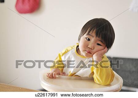 Portrait of baby boy sitting in high chair, resting head on hand View Large Photo Image Stock Image - Portrait of baby boy sitting in high chair, resting head on hand. Fotosearch