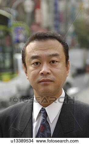 Picture - Portrait of businessman at street, differential focus, Tokyo prefecture, Japan. Fotosearch