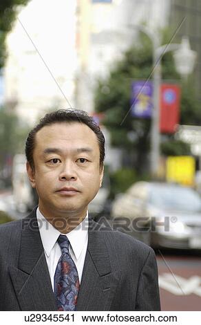 Stock Image - Portrait of businessman at street, differential focus, Tokyo prefecture, Japan. Fotosearch