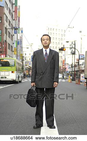 Picture - Portrait of businessman standing at street, Tokyo prefecture, Japan. Fotosearch