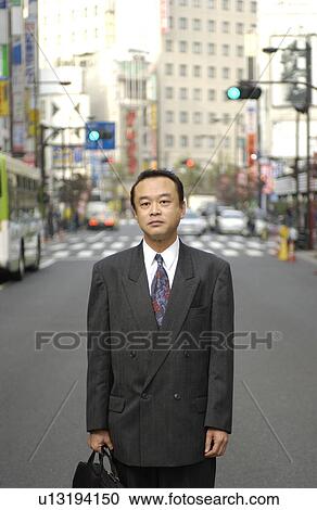 Stock Image - Portrait of businessman standing at street, Tokyo prefecture, Japan. Fotosearch