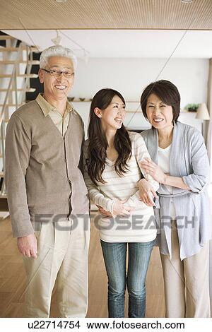 Portrait of family in living room, smiling View Large Photo Image Picture - Portrait of family in living room, smiling. Fotosearch
