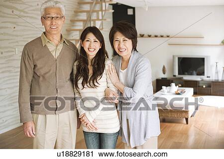 Portrait of family in living room, smiling View Large Photo Image Stock Image - Portrait of family in living room, smiling. Fotosearch