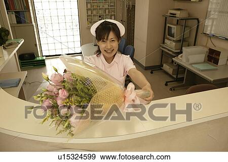 Portrait of female nurse holding flower bouquet, smiling View Large Photo Image Stock Photo - Portrait of female nurse holding flower bouquet, smiling. Fotosearch
