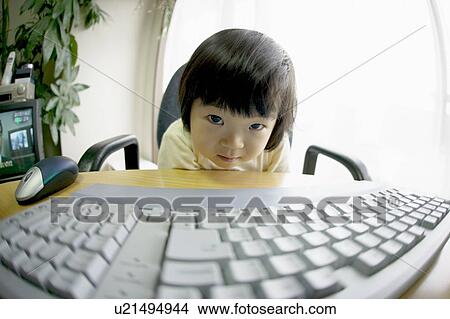 Picture - Portrait of girl sitting at desk, fish-eye lens. Fotosearch
