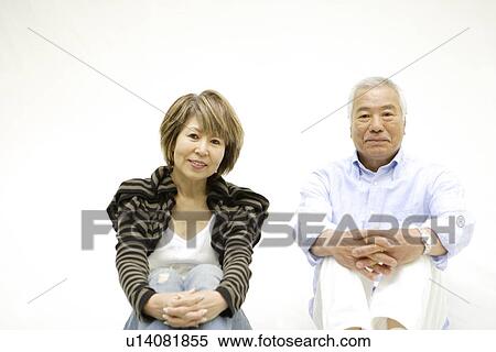 Stock Photography - Portrait of mature woman and senior man, sitting, white background. Fotosearch