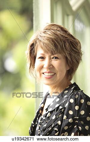 Portrait of mature woman by window, smiling View Large Photo Image Stock Image - Portrait of mature woman by window, smiling. Fotosearch
