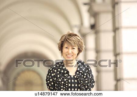 Portrait of mature woman in arcade, smiling View Large Photo Image Stock Photo - Portrait of mature woman in arcade, smiling. Fotosearch