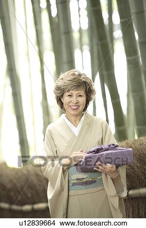 Portrait of mature woman in Kimono holding gift, Kyoto city, Kyoto prefecture, Japan View Large Photo Image Picture - Portrait of mature woman in Kimono holding gift, Kyoto city, Kyoto prefecture, Japan. Fotosearch