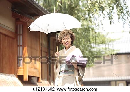 Portrait of mature woman in Kimono holding umbrella and gift, Kyoto city, Kyoto prefecture, Japan View Large Photo Image Stock Image - Portrait of mature woman in Kimono holding umbrella and gift, Kyoto city, Kyoto prefecture, Japan. Fotosearch