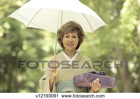 Portrait of mature woman in Kimono holding umbrella and gift, Kyoto city, Kyoto prefecture, Japan View Large Photo Image Stock Image - Portrait of mature woman in Kimono holding umbrella and gift, Kyoto city, Kyoto prefecture, Japan. Fotosearch