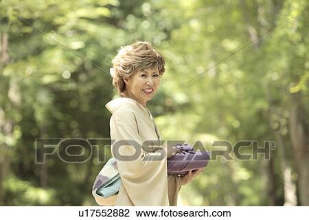 Portrait of mature woman in Kimono holding gift, smiling, Kyoto city, Kyoto prefecture, Japan View Large Photo Image Stock Image - Portrait of mature woman in Kimono holding gift, smiling, Kyoto city, Kyoto prefecture, Japan. Fotosearch