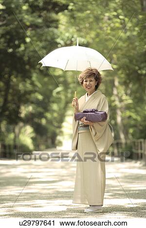 Portrait of mature woman in Kimono holding umbrella and gift, Kyoto city, Kyoto prefecture, Japan View Large Photo Image Stock Image - Portrait of mature woman in Kimono holding umbrella and gift, Kyoto city, Kyoto prefecture, Japan. Fotosearch