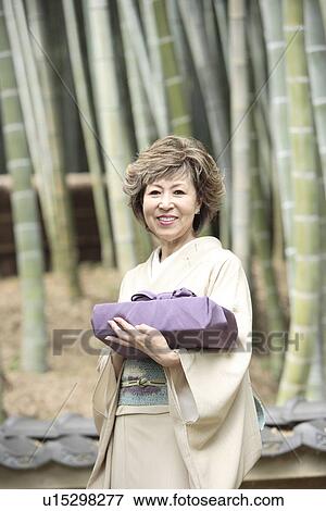 Stock Photo - Portrait of mature woman in Kimono holding gift, Kyoto city, Kyoto prefecture, Japan. Fotosearch