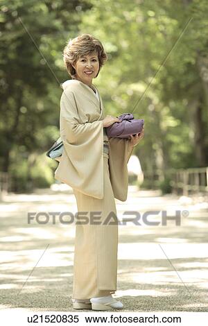 Portrait of mature woman in Kimono holding gift, smiling, Kyoto city, Kyoto prefecture, Japan View Large Photo Image Stock Photography - Portrait of mature woman in Kimono holding gift, smiling, Kyoto city, Kyoto prefecture, Japan. Fotosearch