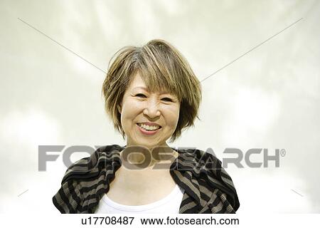 Stock Photo - Portrait of mature woman smiling, white background. Fotosearch