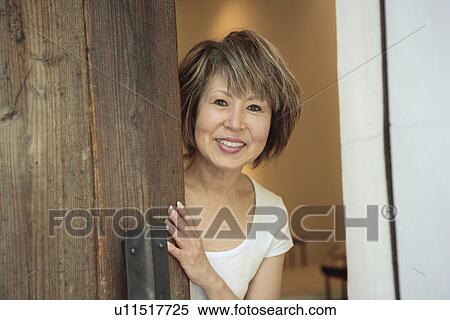 Stock Photography - Portrait of mature woman standing in doorway. Fotosearch