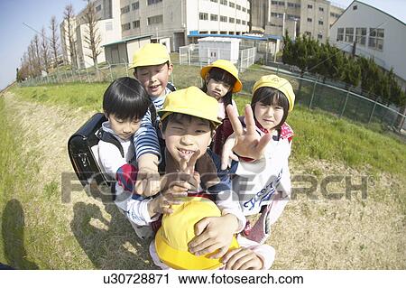 Stock Image - Portrait of school children at riverbank, fish-eye lens. Fotosearch
