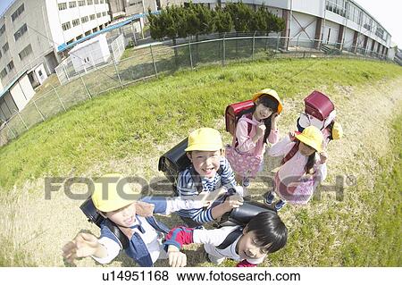 Stock Photo - Portrait of school children at riverbank, fish-eye lens. Fotosearch