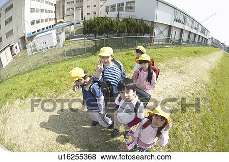 Stock Photo - Portrait of school children at riverbank, fish-eye lens. Fotosearch