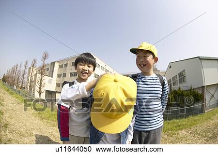 Stock Image - Portrait of schoolboys at riverbank, bowing, fish-eye lens. Fotosearch