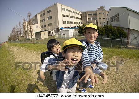 Stock Image - Portrait of schoolboys at riverbank, fish-eye lens. Fotosearch