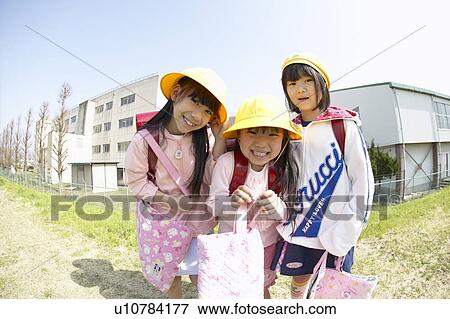 Stock Photo - Portrait of schoolgirls at riverbank, fish-eye lens. Fotosearch