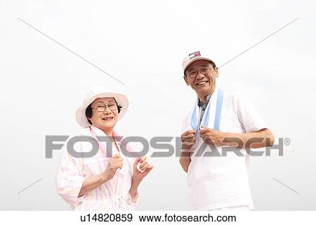 Stock Photo - Portrait of senior couple putting towels around neck, smiling. Fotosearch