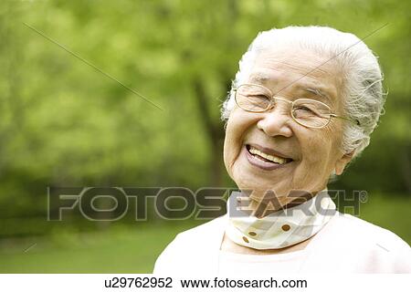 Stock Image - Portrait of senior woman smiling, differential focus. Fotosearch