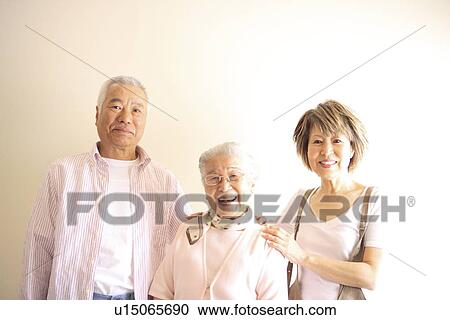 Stock Image - Portrait of two generation family, smiling, white background. Fotosearch
