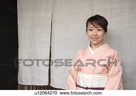 Stock Image - Portrait of woman in Kimono standing in Japanese restaurant entrance, Kyoto city, Kyoto prefecture, Japan. Fotosearch