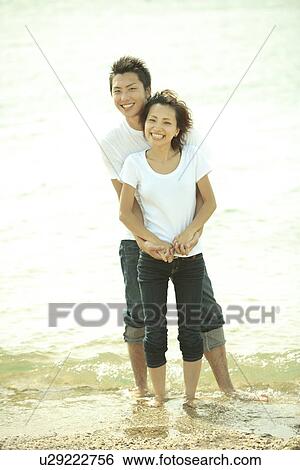 Portrait of young couple embracing at beach, Awaji city, Hyogo prefecture, Japan View Large Photo Image Stock Photograph - Portrait of young couple embracing at beach, Awaji city, Hyogo prefecture, Japan. Fotosearch