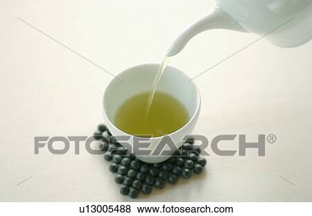Stock Photo - Pouring green tea into a cup. Fotosearch