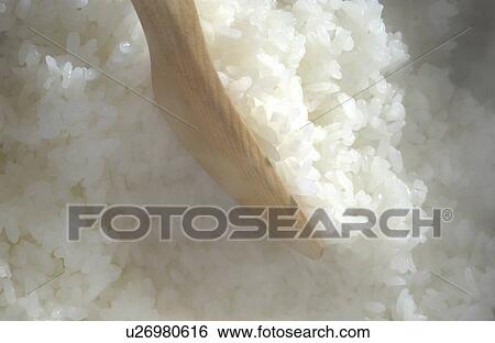 Stock Photograph - Rice and wooden spoon. Fotosearch