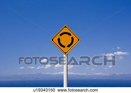 Stock Image - Roundabout sign against sky, computer graphic, copy space. Fotosearch