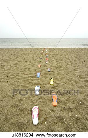 Picture - Sandals placed in lines on beach, Kamakura city, Kanagawa prefecture, Japan. Fotosearch
