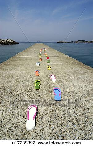 Stock Image - Sandals placed in lines on pier, Kamakura city, Kanagawa prefecture, Japan. Fotosearch