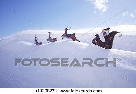 Stock Image - Santa and reindeer decoration in snow. Fotosearch