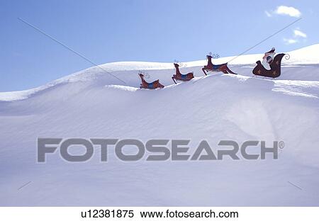 Stock Photography - Santa and reindeer decoration in snow. Fotosearch