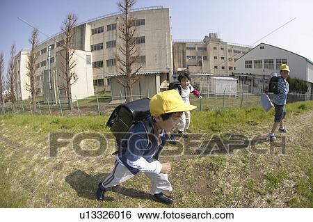 Stock Photograph - Schoolboys running on riverbank, fish-eye lens. Fotosearch