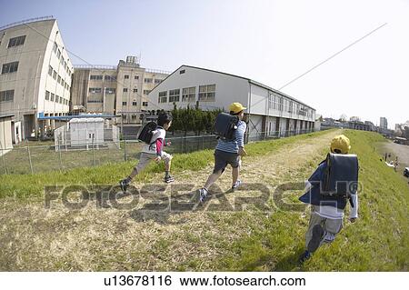 Stock Photograph - Schoolboys running on riverbank, fish-eye lens. Fotosearch