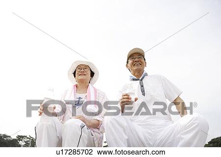 Senior couple holding bottles of water, smiling and sitting View Large Photo Image Stock Image - Senior couple holding bottles of water, smiling and sitting. Fotosearch