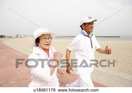 Stock Photo - Senior couple jogging on beach. Fotosearch