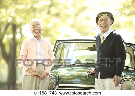 Senior couple standing in front of a car View Large Photo Image Stock Image - Senior couple standing in front of a car. Fotosearch